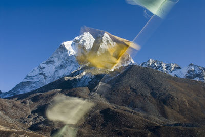 Scenic view of snowcapped mountains against clear blue sky