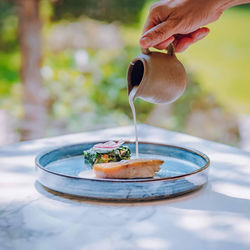 Cropped hand of person holding food on table
