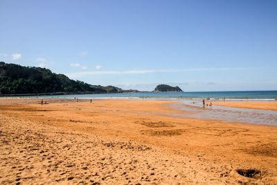 Scenic view of beach against blue sky