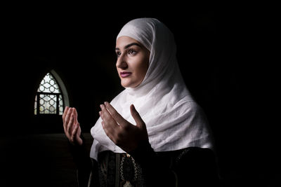 Woman wearing burka in darkroom
