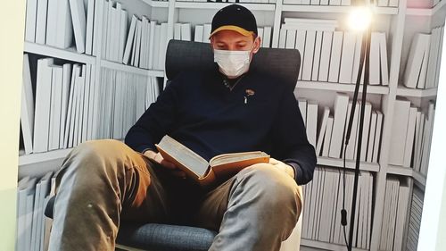 Young man sitting on book
