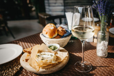 Glass of cold white wine and oven baked camembert cheese