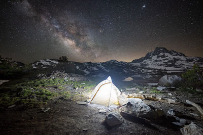 Illuminated tent on mountain against sky at night