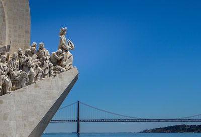 Low angle view of statue against bridge