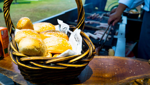 Cropped hand of man making food on barbecue grill