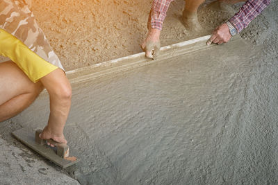 Construction workers paving sidewalk with concrete