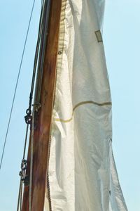 Low angle view of sailboat against clear blue sky