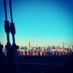 View of cityscape against clear blue sky