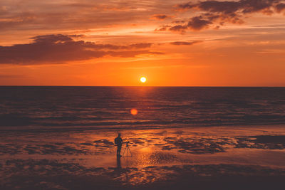 Photographer on beach during sunset