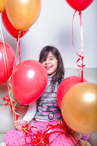 Portrait of a smiling young woman with balloons