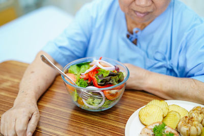 Midsection of man having food on table