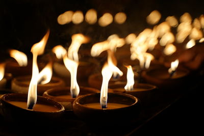 Close-up of burning candles at night