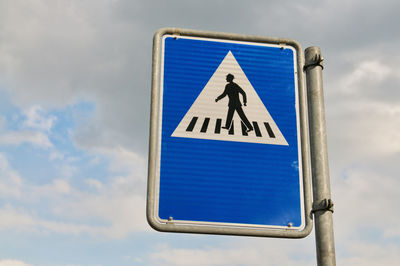 Low angle view of road sign against blue sky