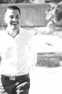 Smiling young man standing on footpath