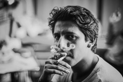 Portrait of young man smoking cigarette outdoors