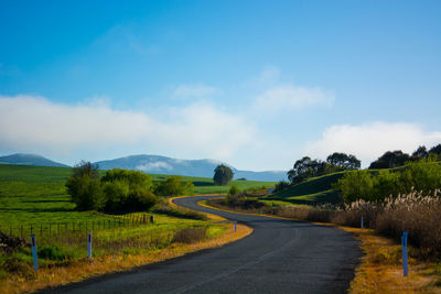 Empty road along countryside landscape