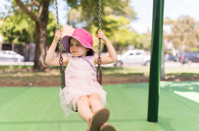 Girl playing with swing in park