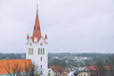 Tower amidst buildings in city against sky