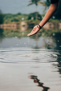 Midsection of woman in lake during rainy season