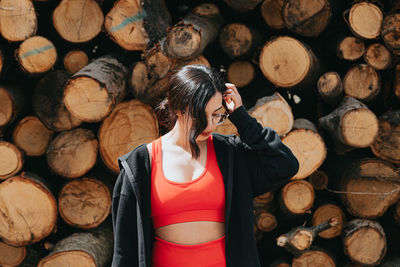 Portrait of woman standing at logs