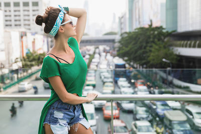 Rear view of young woman standing in city