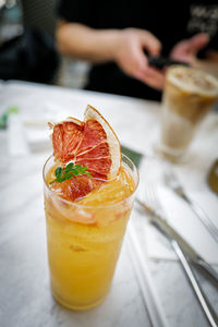 Midsection of woman holding drink on table