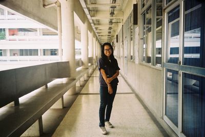 Portrait of smiling young woman standing in building