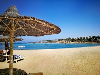 Scenic view of beach against clear blue sky