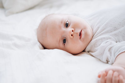 Portrait of cute baby lying on bed