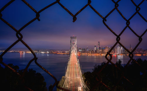 Bridge over river in city against sky