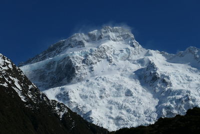 Scenic view of snowcapped mountains against clear blue sky