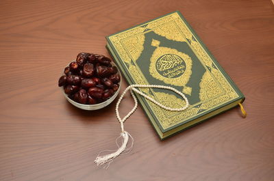 High angle view of koran and beads on table