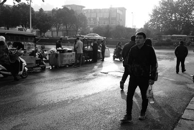 Rear view of people walking on road