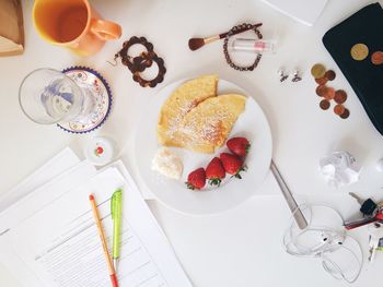 High angle view of breakfast with coins and documents on table