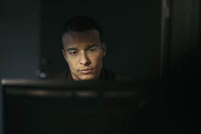 Close-up of businessman using computer in office at night