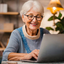 Portrait of grandma using laptop while sitting at home
