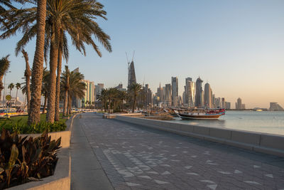 Panoramic view of buildings and palm trees against sky