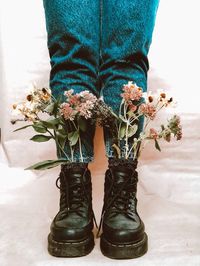 Low section of woman standing on flowering plant