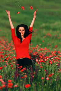 Portrait of smiling young woman by poppy field