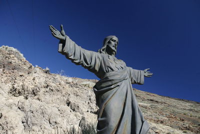 Low angle view of jesus christ statue against mountain