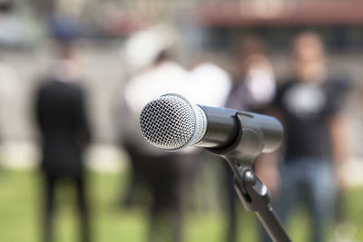 Close-up of microphone against men