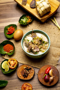 Coto makasar and ketupat, indonesian traditional food, taken with high angle view on table