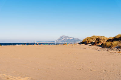 Scenic view of beach against clear blue sky