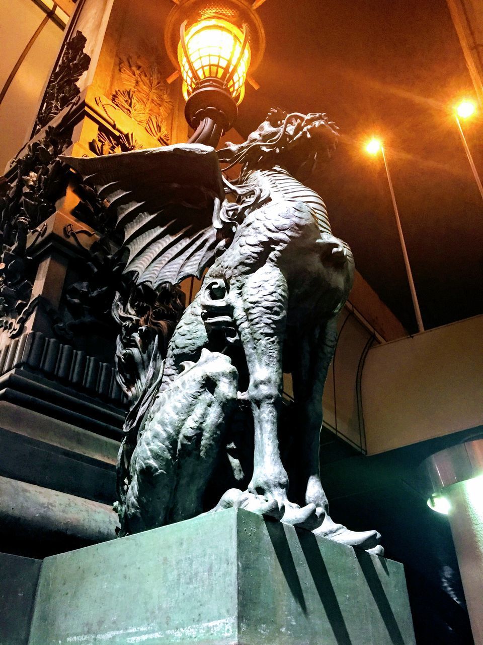 LOW ANGLE VIEW OF STATUE AGAINST ILLUMINATED BUILDING