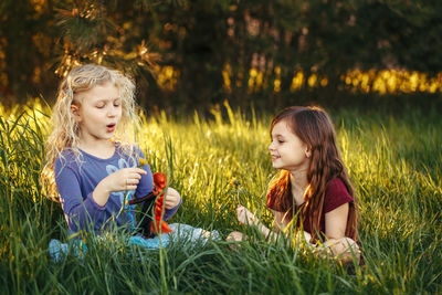 Friends playing with dolls on field