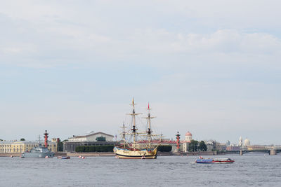 Boats in sea against cloudy sky