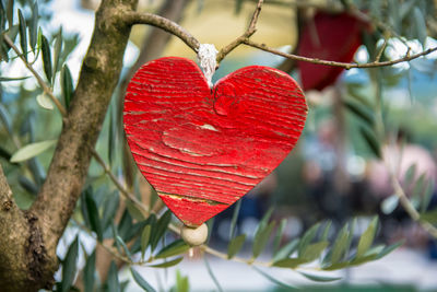 Close-up of red heart shape hanging on tree