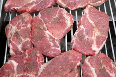 High angle view of meat steaks on barbeque grill