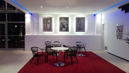 Empty chairs and tables in illuminated room