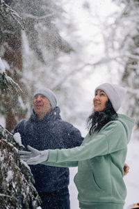 Happy couple playing winter game in forest outdoors. love and leisure concept.